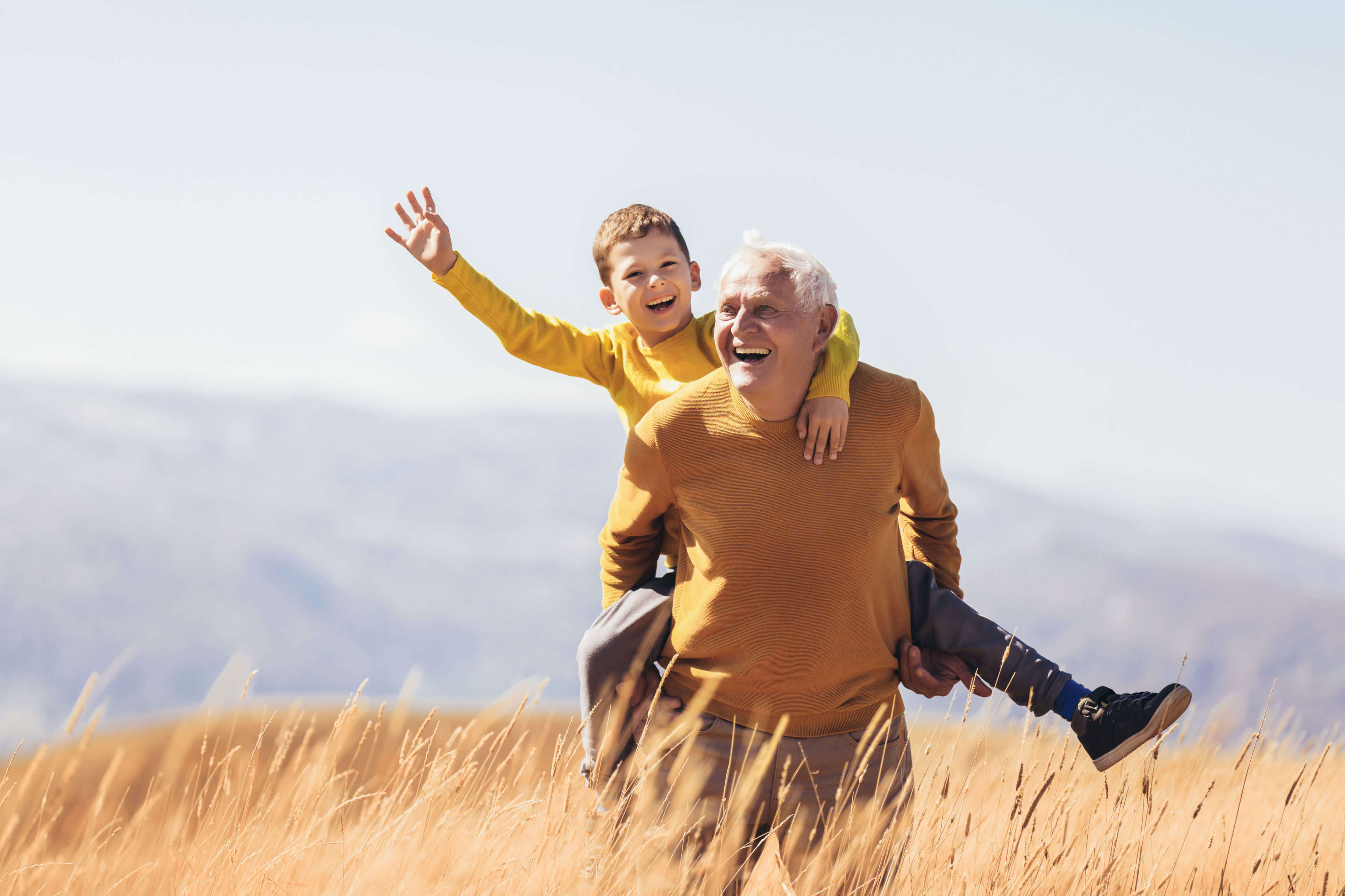 grandson piggyback with his grandfather in autumn